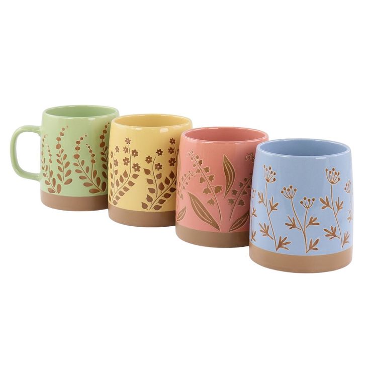 four different colored mugs with designs on them