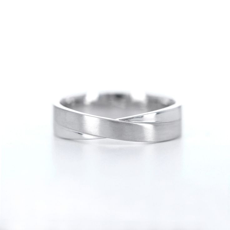 a close up view of a wedding ring on a white surface