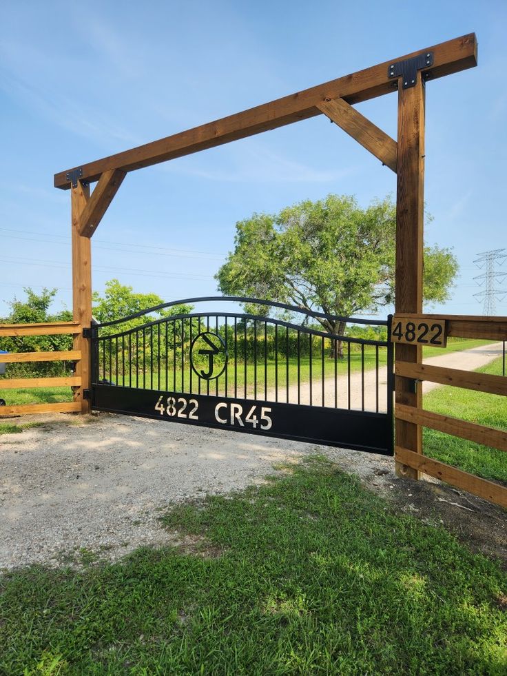 a gate with the number 422 cres on it in front of a grassy field