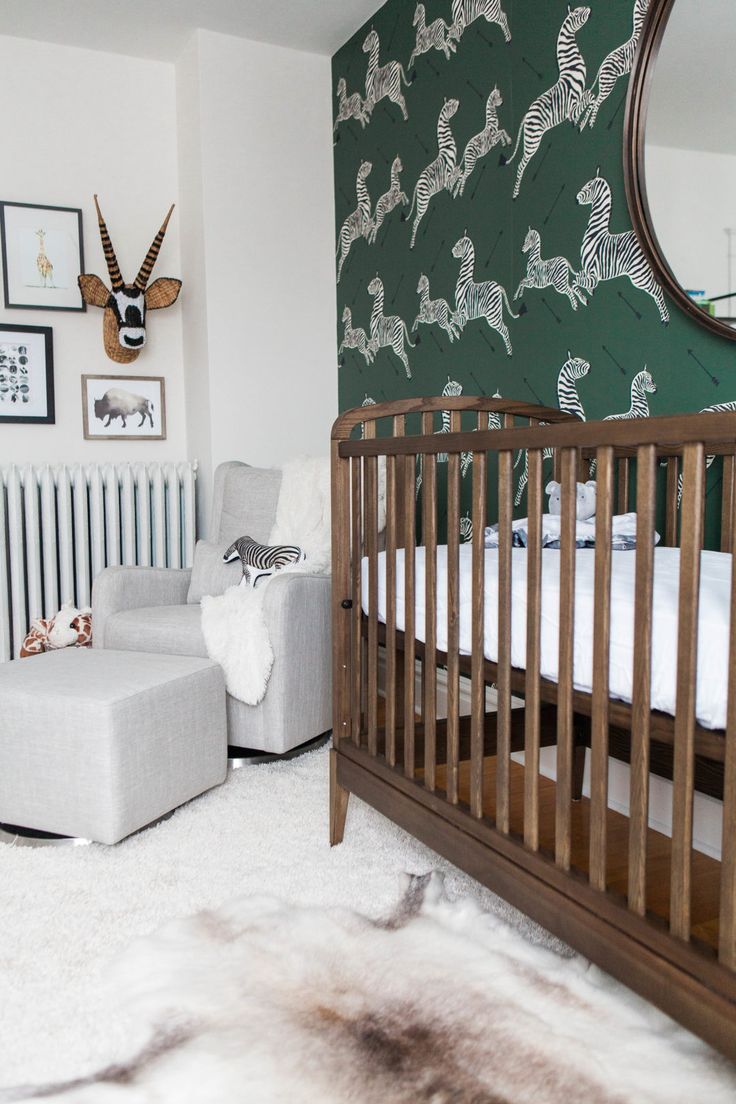 a baby's room with an animal themed wallpaper and white rugs on the floor