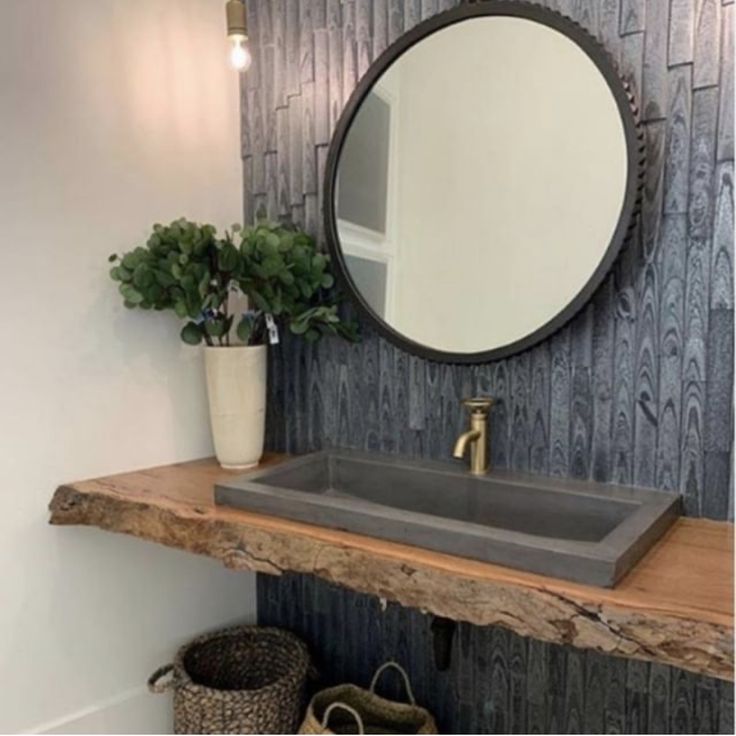 a bathroom with a sink, mirror and basket on the counter top in front of it