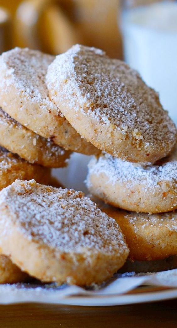 a pile of sugar covered donuts sitting on top of a white plate