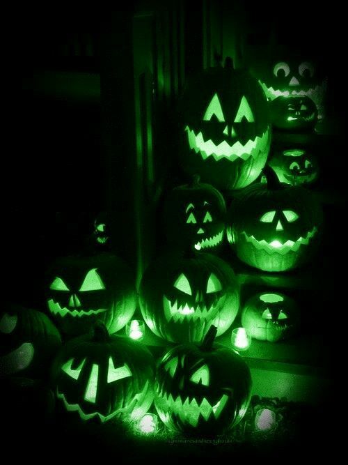 halloween pumpkins lit up in the dark with glowing faces and eyes, all carved to look like jack - o'- lanterns