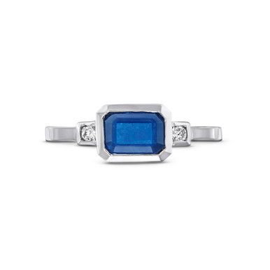 This Emerald Cut Blue Sapphire Diamond Ring features an emerald cut blue sapphire totaling approximately 1.20 carats, accented by brilliant round diamonds on each side. Blue Octagon Sapphire Ring With Diamonds, Octagon Sapphire Ring With Diamond Accent Stones, Blue Octagon Brilliant Cut Sapphire Ring, Blue Octagon Sapphire Ring With Brilliant Cut, Octagon Shaped Blue Sapphire Ring With Brilliant Cut, Blue Sapphire Radiant Cut Promise Ring, Blue Radiant Cut Sapphire Promise Ring, Platinum Blue Sapphire Gemstone Ring, Blue Sapphire Gemstone Ring In Platinum