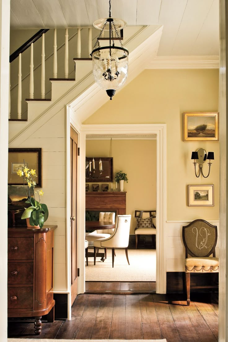 an entry way leading to a living room and dining room with stairs in the background