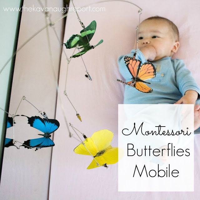 a baby laying on top of a bed next to butterflies