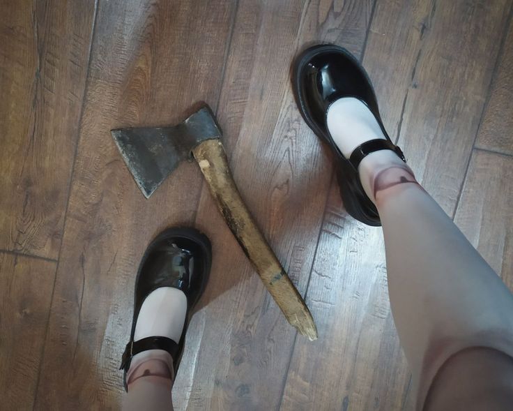 a woman standing on top of a hard wood floor next to a hammer and shoe