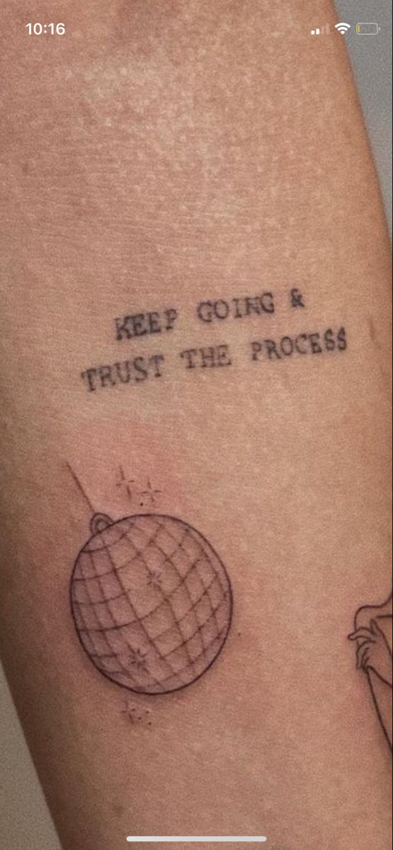 a tattoo saying keep going and trust the process on someone's arm with an image of a globe