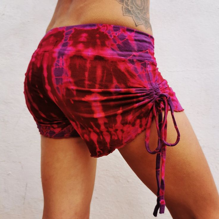 Tie Dye Yoga Bootie Shorts Model 168 cm size M These super shorts will heads wherever you go. Soft and comfortable chinch shorts , perfect for that yoga booty . Adjustable fit by pulling strings on side makes shorts tighter and shorter, will costume contour to your body shape for a flattering fit. Hand tied and dyed process results in variation of pattern from one garment to next, will be similar to picture. MATERIAL 95% rayon fibre made from regenerated Bamboo plants that give the same feeling Stretch Beachwear Shorts For Festival, Purple Yoga Bottoms With Built-in Shorts, Beachwear Bottoms With Built-in Shorts For Festival, Stretch Red Yoga Shorts, Stretch Red Shorts For Yoga, Cotton Athletic Shorts For Yoga, Beachwear Bottoms With Drawstring For Festival, Cotton Bottoms With Built-in Shorts For Yoga, Stretch Short Bottoms With Drawstring