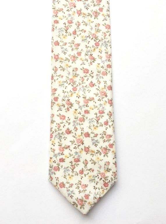 DESCRIPTION: This lovely men's skinny tie has been handmade using a beautiful vintage first floral cotton.FABRIC: Cotton.LINING FABRIC: Cotton.--------------------------------------------------------------------------------------------DETAILS:• Made the traditional way with fabric cut on the bias• Each tie has canvas lining throughout• Fabric lining just at the tip on each end of the tie• Width at the widest part measures approx 2.5 inches• The length of each tie is approx 58 Inches• Comes packa Classic Floral Print Tie For Gift, Classic Floral Print Tie As A Gift, Classic Floral Print Ties As Gifts, White Floral Print Suit And Tie Accessories For Summer, White Floral Suit And Tie Accessories For Spring, White Floral Print Suit And Tie Accessories For Spring, Dapper White Suit And Tie Accessories For Summer, Classic White Tie With Floral Print, Classic Floral Print Ties For Summer