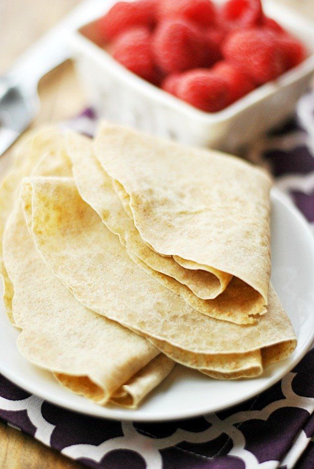 there is a white plate with tortillas and raspberries on it