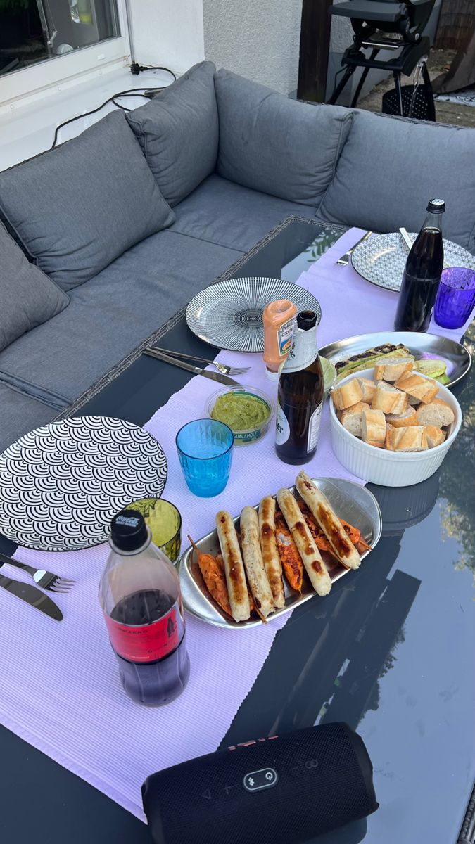 a table topped with plates and bowls filled with food on top of a purple cloth