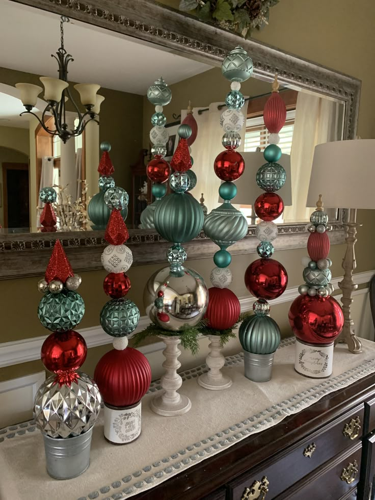 a christmas tree made out of ornaments on top of a dresser next to a mirror