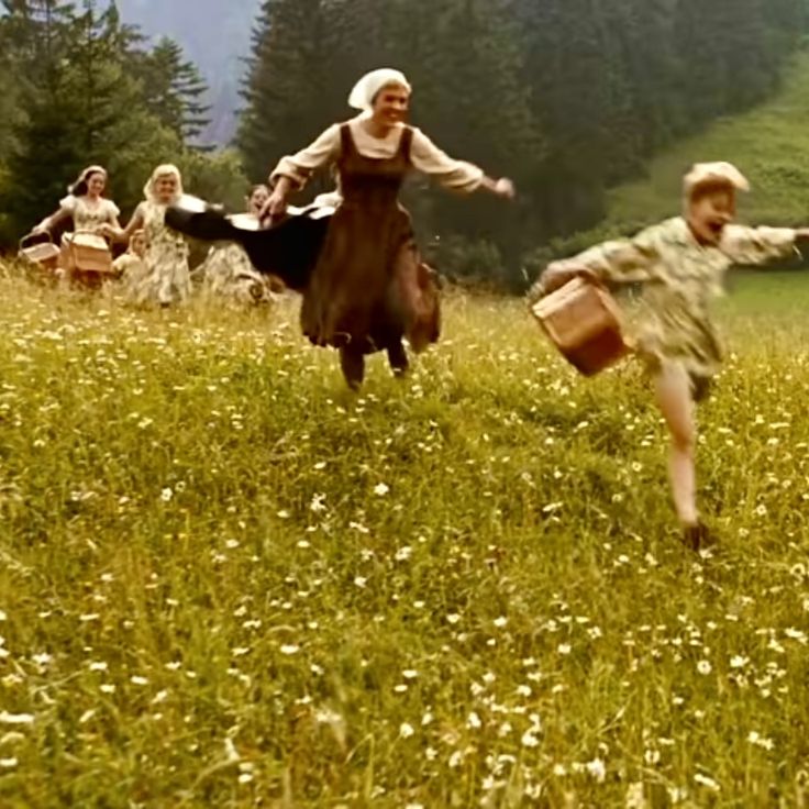 several people are playing in the grass with their arms outstretched and legs spread out as if they're dancing