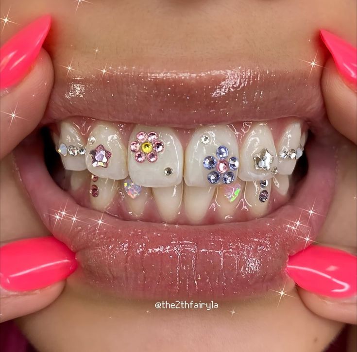 a woman with pink nails holding up her teeth