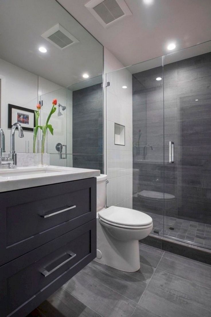 a bathroom with a toilet, sink, and shower stall is pictured in this image