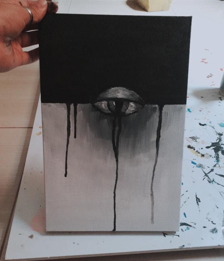 a person is painting on a canvas with black and white paint that has dripping from it