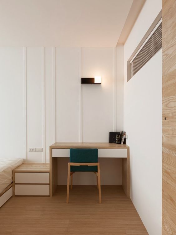 an empty room with a desk, chair and stairs leading to the bed area that is made out of wood