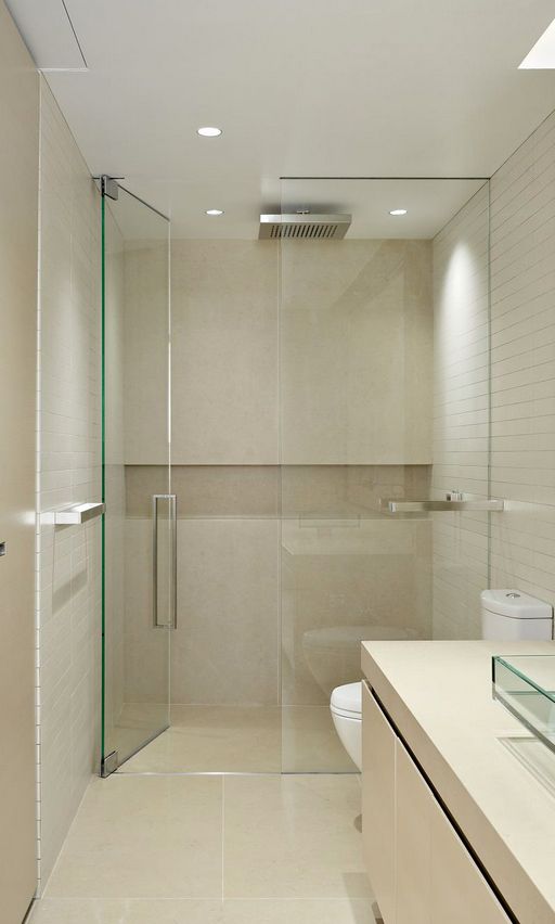 a bathroom with a walk in shower next to a white toilet and counter top sink