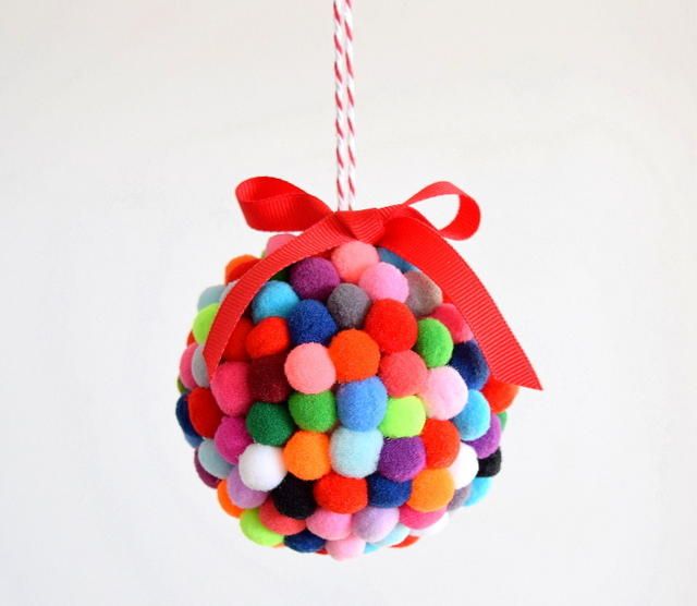 an ornament made out of pom - poms hanging from a red ribbon