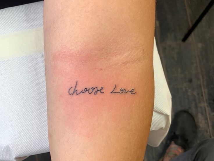 a person with a tattoo on their arm that says, choose love in cursive writing