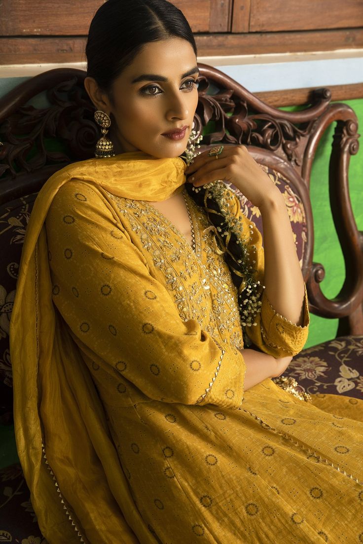 Yellow anarkali with hand embroidered yoke. Comes with churidar and crushed silk dupatta.
Component: 3
Pattern: Embroidered
Type Of Work: Floral Motifs
Neckline: V-Neck
Sleeve Type: Three Quarter
Fabric: Anarkali: Tissue Chanderi, Churidar: Lycra Net, Dupatta: Silk
Color: Yellow
Other Details: 
Floral motif embroidery
Cutwork hem lace
Note: The outfit worn by the model on the back is not for sale
Occasion: Mehendi and Haldi - Aza Fashions Straight Kurta With Dabka And Kundan, Gold Anarkali Lawn Suit With Dabka, Designer Chanderi Kurta With Dabka Work, Festive Designer Dola Silk Lawn Suit, Navratri Dabka Kurta In Chinon, Festive Kundan Lawn Suit For Eid, Unstitched Gold Anarkali Lawn Suit, Unstitched Suit With Dabka For Diwali In Kundan Material, Diwali Designer Dola Silk Lawn Suit