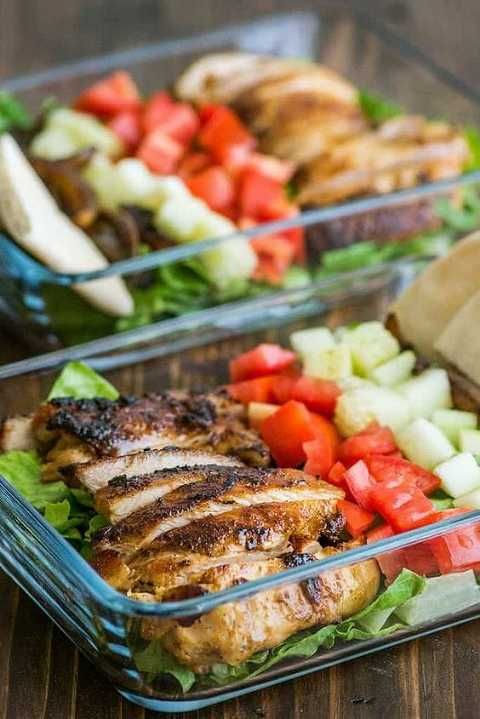 two plastic containers filled with food on top of a wooden table