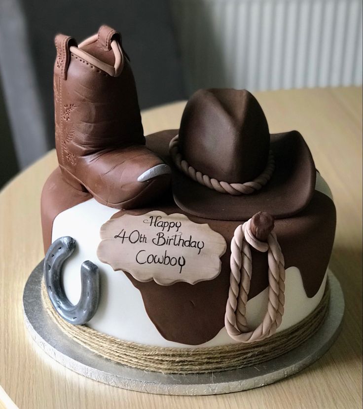 a birthday cake decorated with cowboy boots and rope