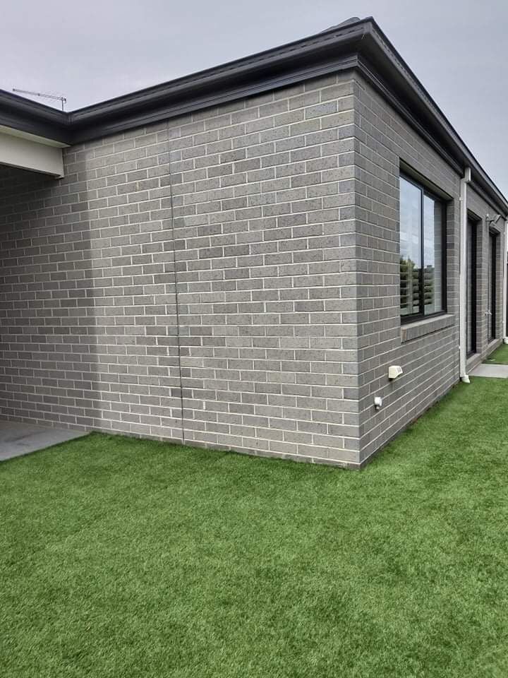 a brick building sitting on top of a lush green field