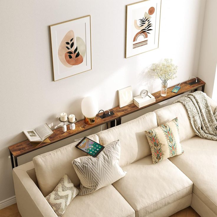 a living room with white couches and pictures on the wall above it, along with other decor items