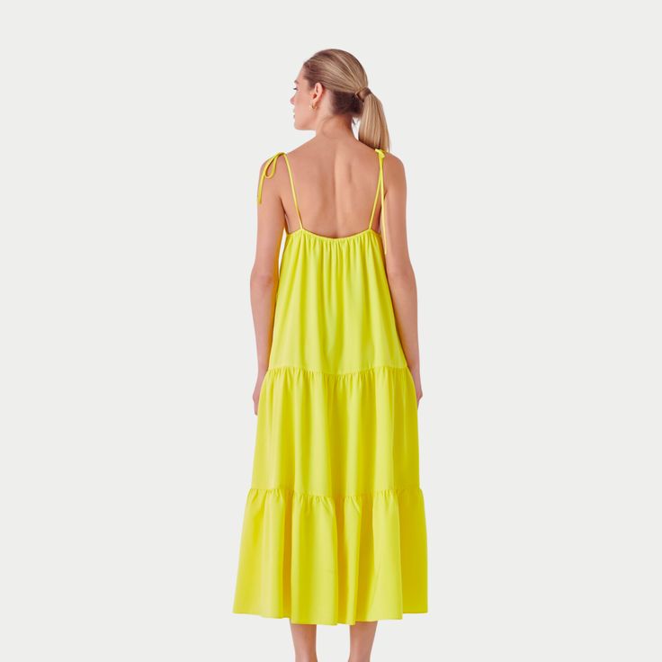 Capture the vibrancy of summer with the Nicola Maxi Dress, a radiant addition to your wardrobe. This sleeveless, floor-grazing dress is a celebration of sunny days with its eye-catching hue and elegant V-neck design. The functional spaghetti bow tie adds a playful yet sophisticated touch, allowing for a personalized fit. The side zipper and back elastic band ensure ease of wear and comfort, while the full lining provides a smooth silhouette. Vibrant Summer Sundress For The Beach, Yellow Spaghetti Strap Maxi Dress For Beach Season, Vibrant Summer Beach Sundress, Vibrant Sleeveless Maxi Dress For Spring, Sleeveless Yellow Beach Dress For Summer, Yellow V-neck Beach Dress For Spring, Vibrant Summer Maxi Dress, Vibrant Green Maxi Dress For Spring, Summer Yellow Midi Dress With Spaghetti Straps