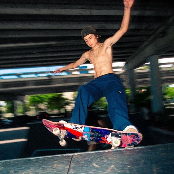 a shirtless man riding a skateboard on top of a cement ramp in a parking garage