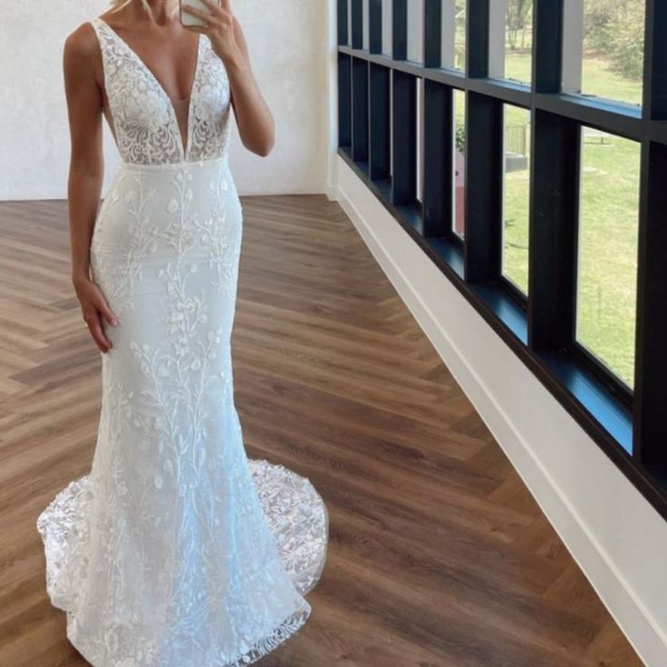 a woman is taking a selfie in her wedding dress while standing on the floor