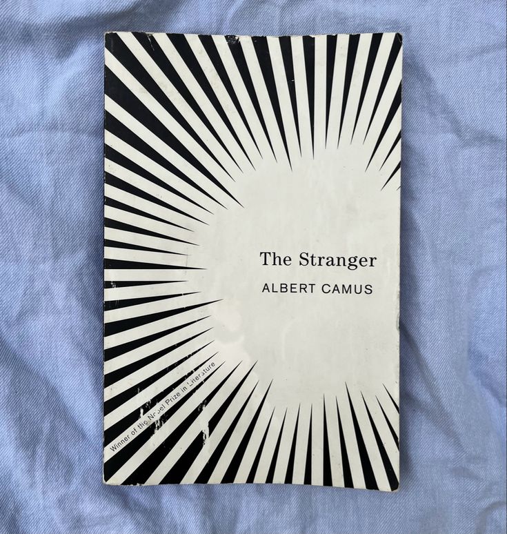 the stranger by albert camus is on a blue sheet with black and white stripes