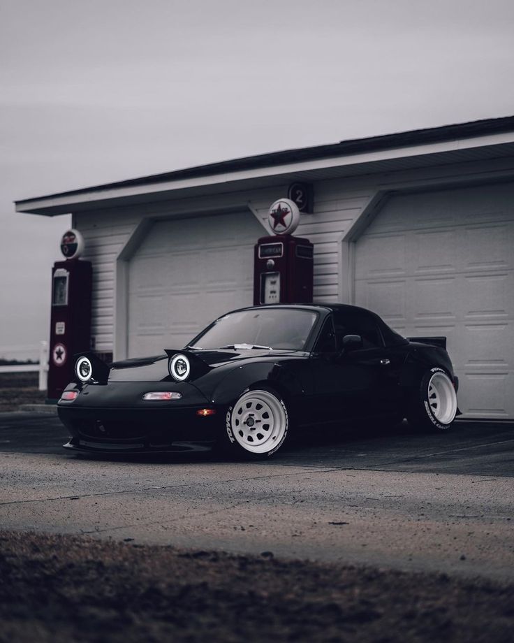 a black car parked in front of a garage