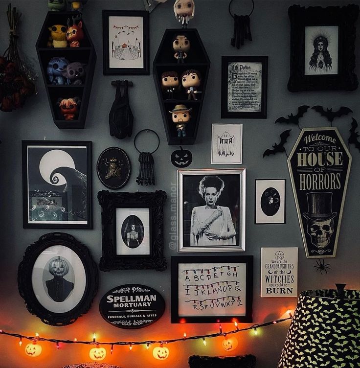 there are many halloween decorations on the wall with pictures and lights in front of them