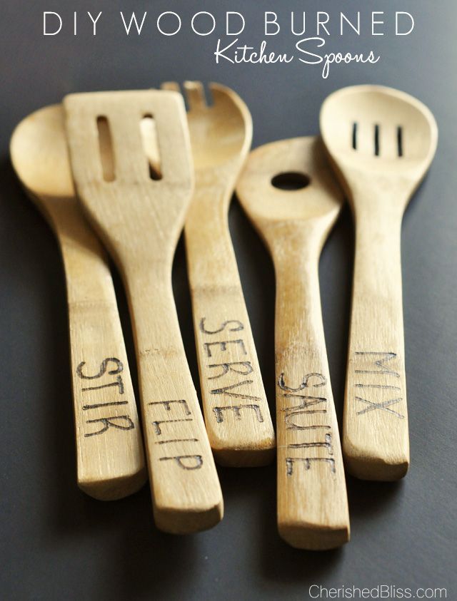 four wooden spoons with writing on them are sitting next to each other and one has a spatula in the shape of a fork