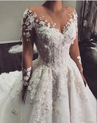 a woman in a white wedding dress standing next to a mirror