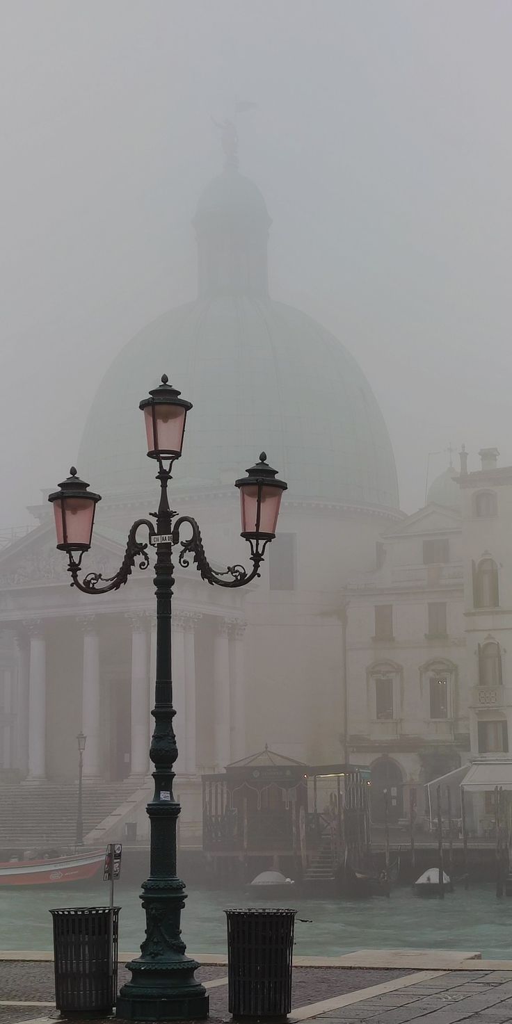 a street light sitting on the side of a road in front of a large building