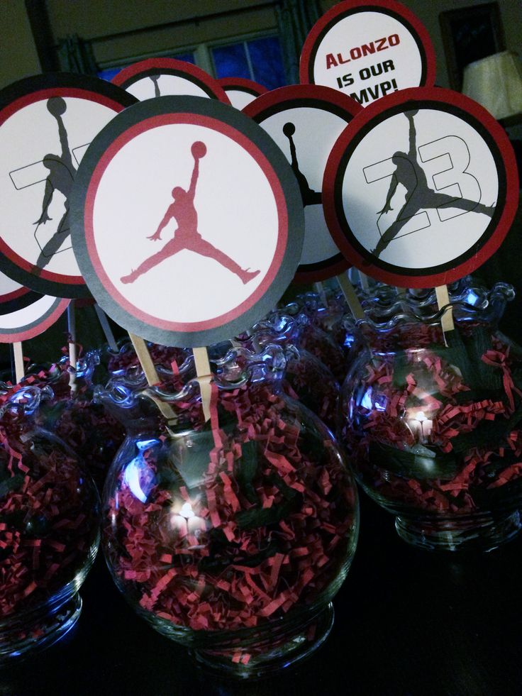 there are many air jordan cupcake toppers in the vases on the table