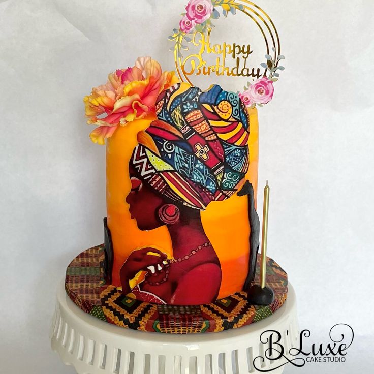 a birthday cake decorated with an african woman's head and flowers on the top