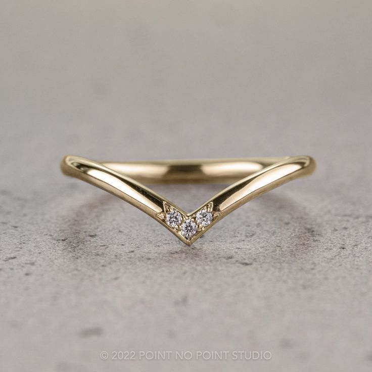 a gold ring with two diamonds on it