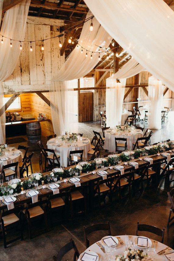 the tables are set up for an event with white draping and floral centerpieces