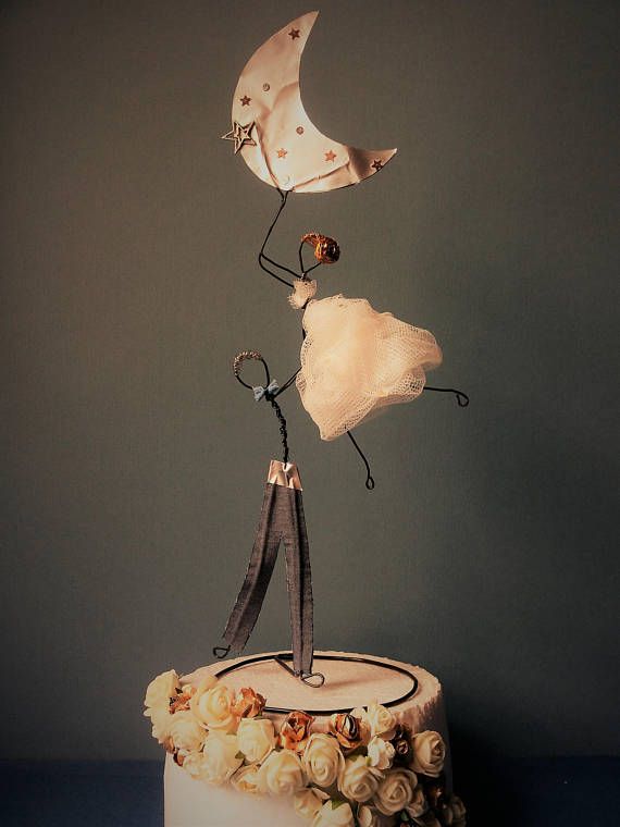 a wedding cake decorated with an umbrella and bride's dress