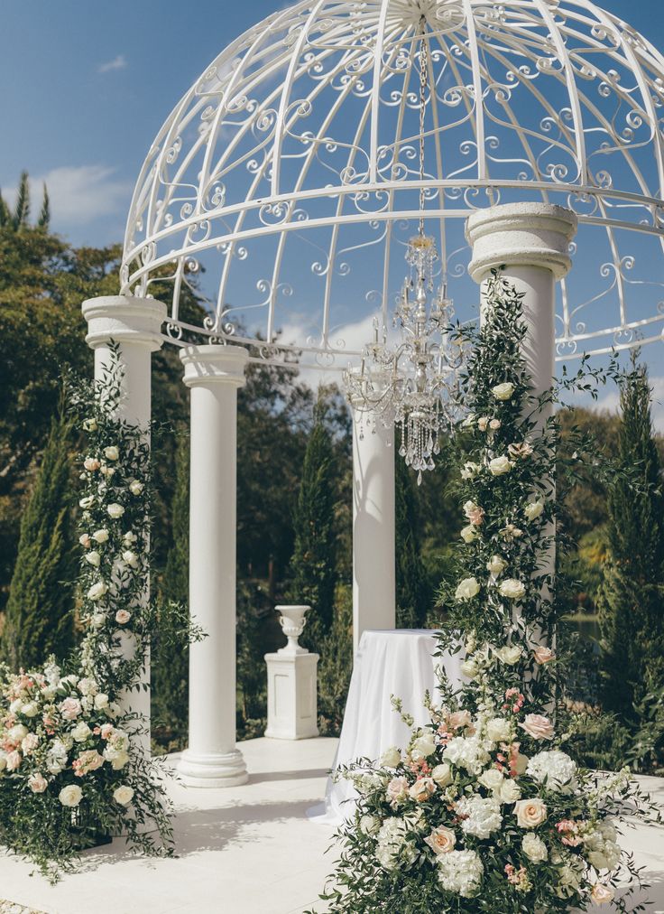 an outdoor wedding setup with flowers and chandelier