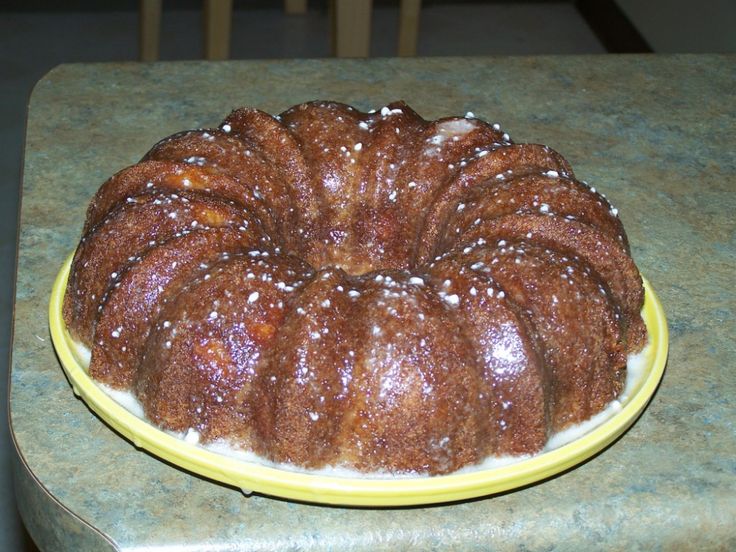 a bundt cake sitting on top of a yellow plate covered in powdered sugar