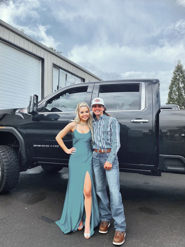 a man and woman standing in front of a truck