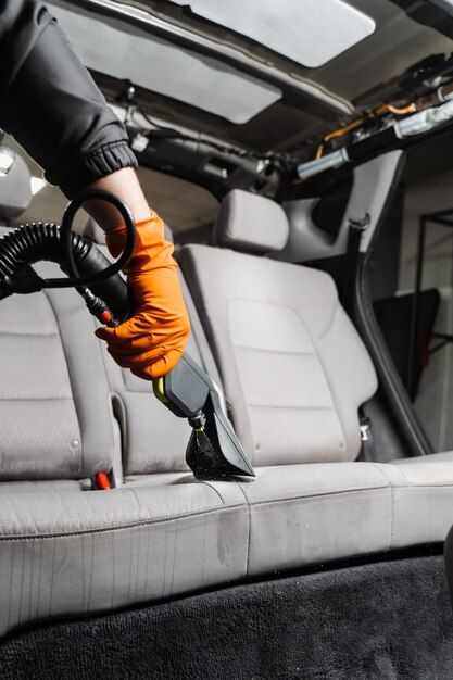 a person is vacuuming the seats in a vehicle with an electric blow dryer