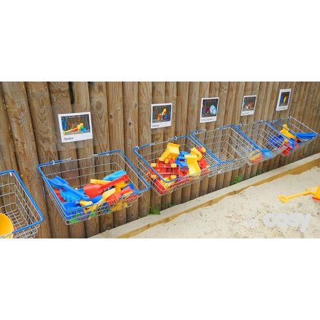 three baskets filled with toys next to a wooden fence