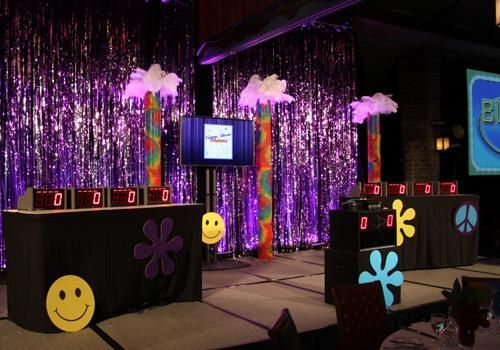 a stage set up for an event with balloons and streamers on the wall behind it